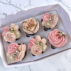 Mother’s Day cupcakes with pink, orange and purple buttercream decorations in gift box