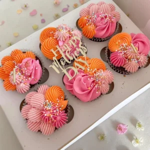 Mother’s Day cupcakes with pink, orange and purple buttercream decorations in gift box